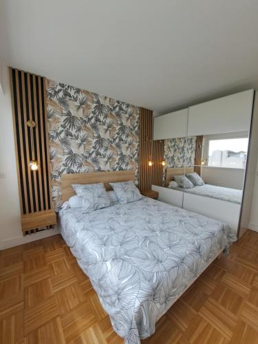 a bedroom with a large bed and a mirror at Appartement de standing in Créteil