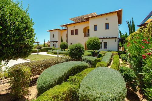 a garden in front of a house with trimmed bushes at Luxury Villa AJ 06 with private heated pool in Paphos City