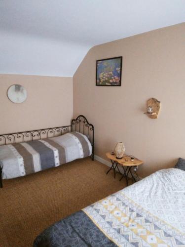 ein Hotelzimmer mit 2 Betten und einem Tisch in der Unterkunft La Maisonnette de Suzette in Port-sur-Saône
