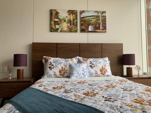a bedroom with a bed with two paintings on the wall at Blue & Yellow Apartment HP - Sur in Mexico City