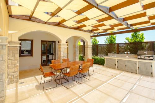an outdoor patio with a wooden table and chairs at Luxury Villa AJ 06 with private heated pool in Paphos City