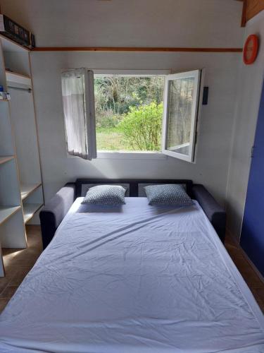 a bed in a small room with a window at Chalet 6 places in Saint-Thomas-en-Royans