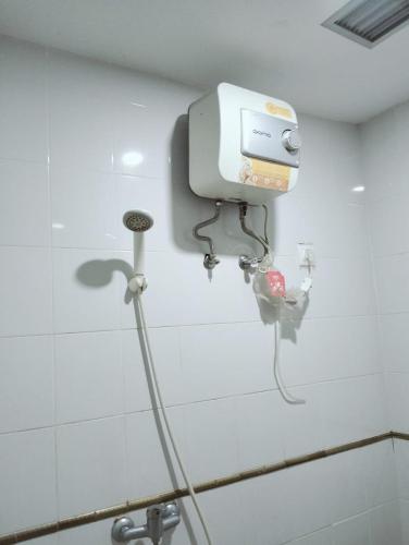 a hair dryer on the wall of a bathroom at The alt room by Vivo apartemen in Seturan