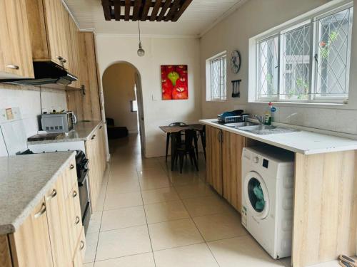 a kitchen with a washer and dryer in it at Peaceful getaway in Cape Town
