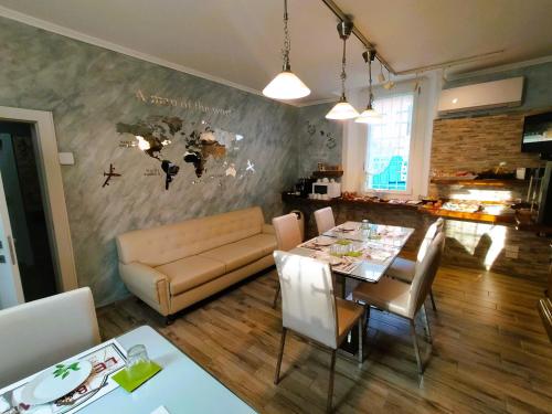 a dining room with a table and a couch at B&B Le Palme in Appiano Gentile