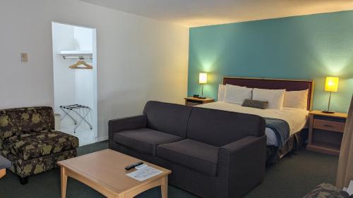 a hotel room with a bed and a couch at Howard Johnson by Wyndham Downtown Kamloops in Kamloops