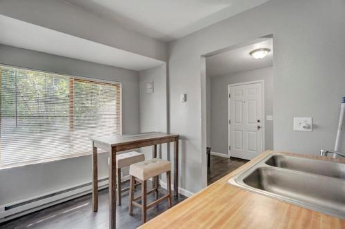a kitchen with a table and a sink next to a window at Charming Half Pint Downtown Stay Pet Friendly in Colorado Springs