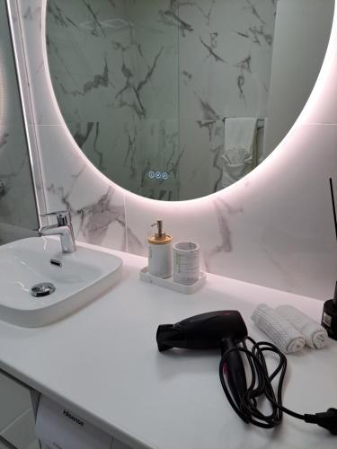 a white bathroom with a black phone on a counter at Appartement de standing in Créteil