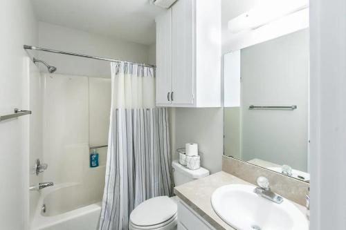 a white bathroom with a toilet and a sink at The Oasis - A in Clovis