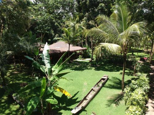 a garden with green grass and a wooden raft at Bahia Soul - Casa Mutá - Barra Grande - Península de Maraú in Barra Grande
