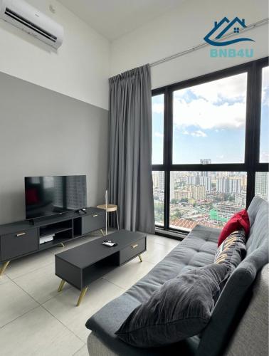 a living room with a couch and a large window at Urban Suites @ George Town Penang by BNB4U in George Town