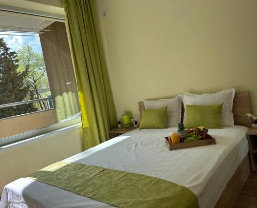 a bedroom with a bed with a tray of fruit on it at Уютен нов апартамент - Стара Загора in Stara Zagora