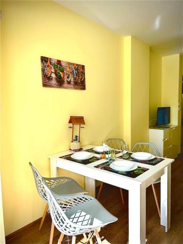 a dining room table with chairs and a table with plates at Уютен нов апартамент - Стара Загора in Stara Zagora