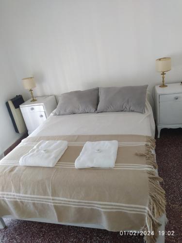 een slaapkamer met een bed met twee handdoeken erop bij La casa in Gualeguaychú