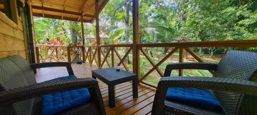 a screened in porch with two chairs and a table at Cabinas Costa Tropicana in Uvita