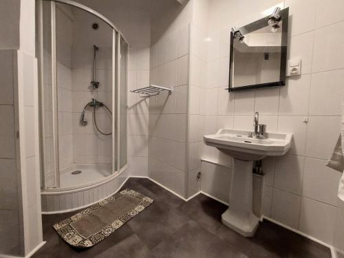 une salle de bain blanche avec un lavabo et une douche dans l'établissement Résidence Le Savoy - Spacieux logement, belle vue au coeur de la ville ! MAE-7531, à Aix-les-Bains