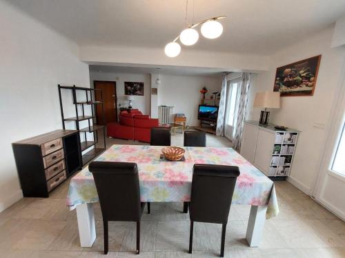 une table à manger avec des chaises et un canapé rouge dans l'établissement Résidence Le Savoy - Spacieux logement, belle vue au coeur de la ville ! MAE-7531, à Aix-les-Bains