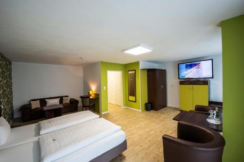 a living room with a bed and a flat screen tv at PANORAMA HOTEL in Neustadt an der Weinstraße in Neustadt an der Weinstraße
