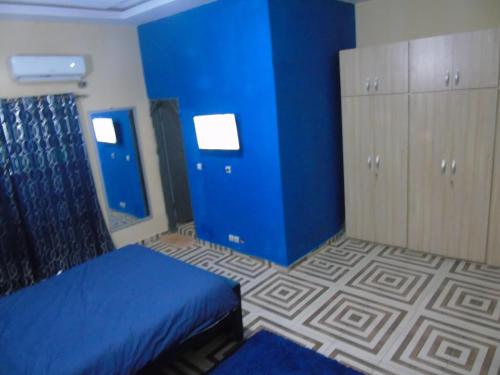 a bedroom with blue walls and a bed and cabinets at Here is our lovely 1-Bed Apartment in Abidjan in Cocody