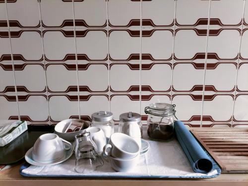 um balcão de cozinha com uma bandeja de utensílios e chávenas em Il cortile di zia em Cagli