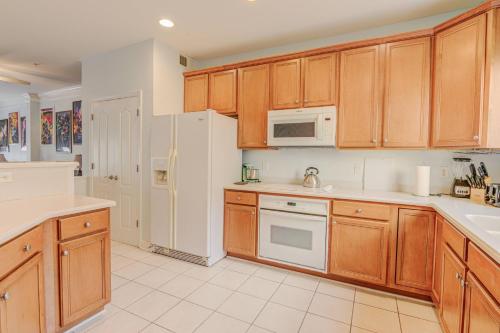 a kitchen with wooden cabinets and a white refrigerator at Glen Riddle 102 in Berlin