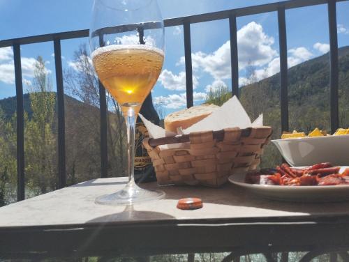 un bicchiere di vino seduto su un tavolo con un piatto di formaggio di Alojamiento Gorga-Ordesa, en Boltaña a Boltaña