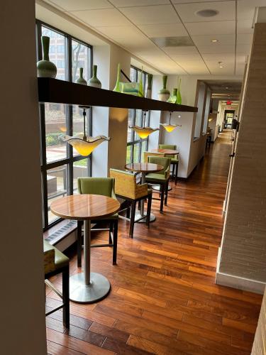 a dining room with tables and chairs and windows at Chicago Marriott Suites O'Hare in Rosemont