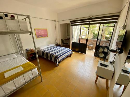 a bedroom with two bunk beds and a desk at Hostel Hospedarte Chapultepec in Guadalajara