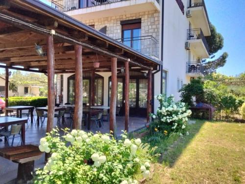 a patio of a house with tables and chairs at GuestHouse Moco Forest in Ulcinj