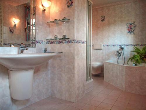 a bathroom with a sink and a tub and a toilet at Holiday apartment Sunflower in Marpingen