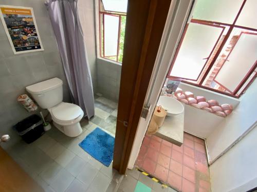 a bathroom with a toilet and a sink and a window at Hostel Hospedarte Chapultepec in Guadalajara