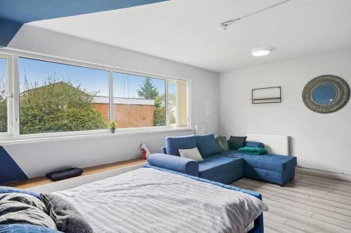 a bedroom with a bed and a couch and a window at Cosy Retreat: Near Attractions & Comfortable! in Birmingham