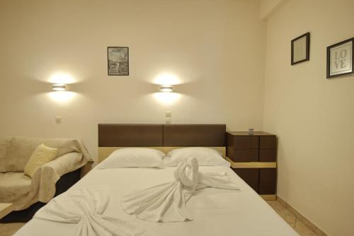 a bedroom with a bed and a chair and lights at Studios Nelli Alonissos in Patitiri
