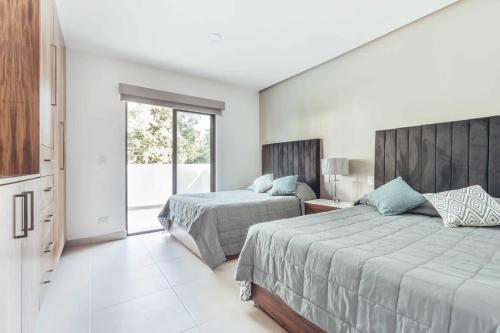 1 dormitorio con 2 camas y ventana en DellaTerra-1-PV, en Bucerías