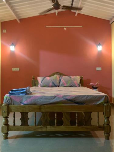 博格馬洛的住宿－Elite Guest House Bogmalo，红色墙壁的房间里一张床位