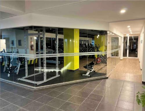 a gym with glass walls and exercise equipment at Bonito departamento en CDMX in Mexico City