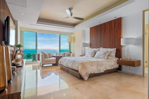 a bedroom with a large bed and a living room at Shangri-La Torre5-7B-PV in Puerto Vallarta