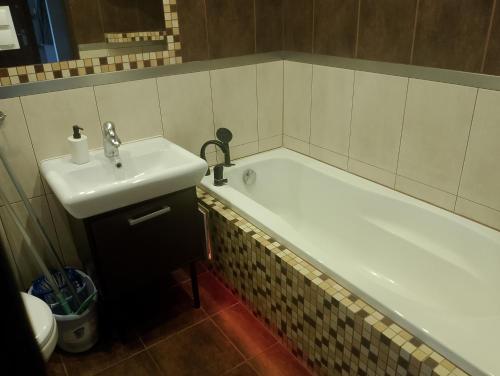 y baño con bañera y lavamanos. en Apartament Rodzinny, en Bydgoszcz