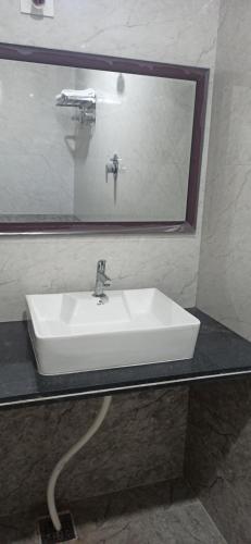 a white sink in a bathroom with a mirror at Kuber Residency in Tirupati