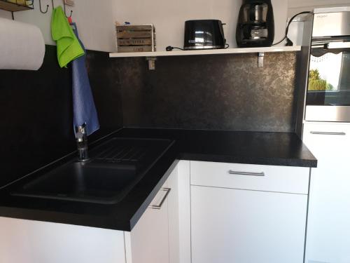 a kitchen with a black counter top and a sink at Home Sweet Klein ilsede in Ilsede