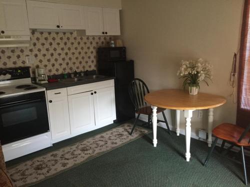 a kitchen with a table and a small table and a table and chairs at Highland Hills Motel & Cabins in Boone