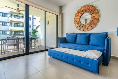 een blauwe bank in een woonkamer met een tafel bij Amazing Condo with Pool in Nuevo Vallarta 