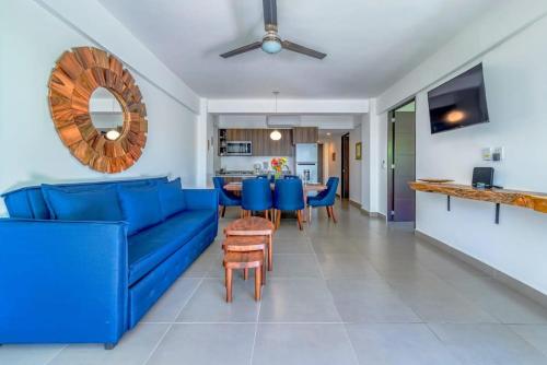 een woonkamer met een blauwe bank en een tafel bij Amazing Condo with Pool in Nuevo Vallarta 