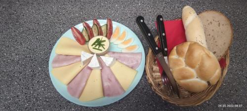 a plate of cheese and bread next to a basket of bread at Pension u Havrana in Jetřichovice