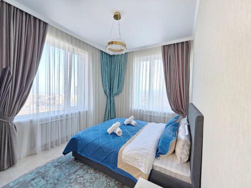 a bedroom with a bed with two stuffed animals on it at ЖК ATREA 2 room Apartment in Almaty