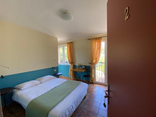 a bedroom with a bed and a window at Auberge la Table du Curé in Cucugnan