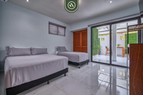 a bedroom with two beds and a balcony at Sonnrisa Condominums 1 in Puerto Vallarta