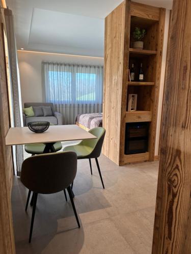 a room with a table and two chairs and a bedroom at Origini Holidays in Sedico