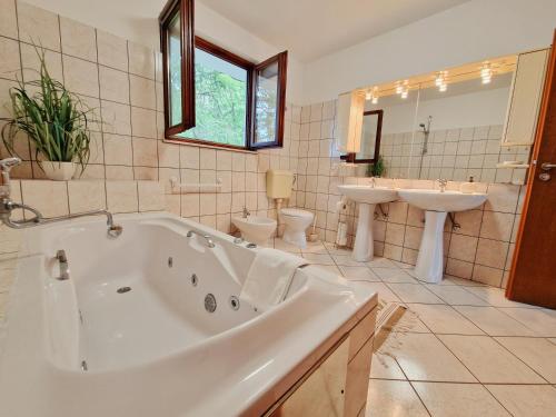 La salle de bains est pourvue de 2 lavabos, d'une baignoire et de 2 toilettes. dans l'établissement Holiday Home Omindula, à Jesenice