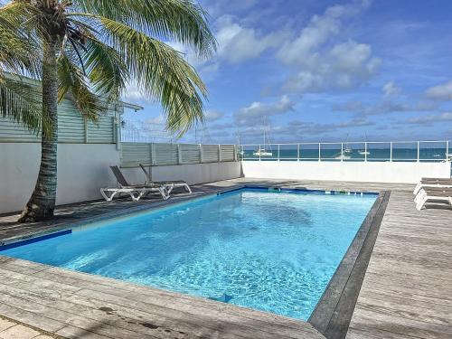 a swimming pool with a view of the ocean at Kokonut Sea view Beach Front Pool Central Garage in Grand Case